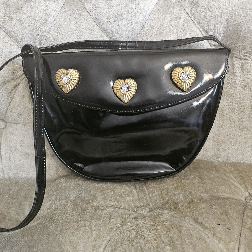 Black crossbody bag with meatl heart embellish.